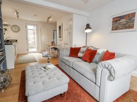 A living room with a sofa and dining area at Fisherman’s Cottage