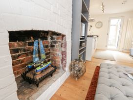 A living room with a model sailboat in the fireplace at Fisherman’s Cottage