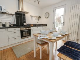 A kitchen with a dining table and cooking appliances at Fisherman’s Cottage