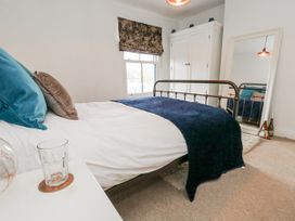 A bedroom with a bed and wardrobe at Fisherman’s Cottage