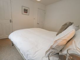 A bedroom with a bed and a framed picture at Fisherman’s Cottage