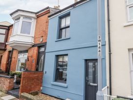 A blue house with a door and windows at Fisherman’s Cottage