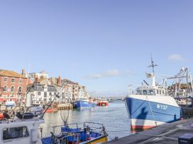 A harbor with boats and buildings by the water at Fisherman’s Cottage