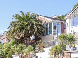 A house with a large palm tree and other plants in the garden at House of Emma in Paignton