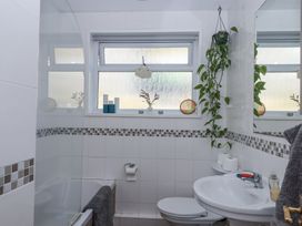 A bathroom with a bathtub toilet sink window and plants at House of Emma in Paignton