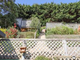 An outdoor garden area with wooden lattice fencing greenery and steps leading up to an elevated section at House of Emma in Paignton
