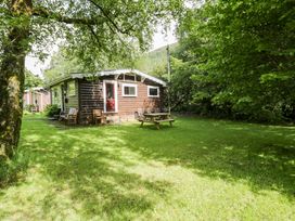 A cabin with a picnic table and chairs surrounded by grass at Ty Bedwen in Dinas Mawddwy
