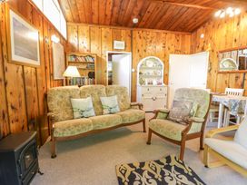 A living room with seating and a bookshelf at Ty Bedwen in Dinas Mawddwy