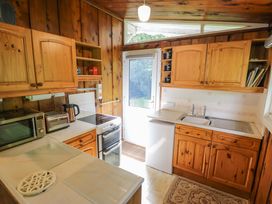 A kitchen with wooden cabinets and appliances at Ty Bedwen in Dinas Mawddwy