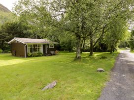 A cabin surrounded by trees and grass at Ty Bedwen in Dinas Mawddwy