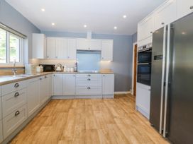 A kitchen with cabinets and appliances at Tirionfa in Talsarnau