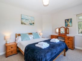 A bedroom with a bed and a dresser at Tirionfa in Talsarnau