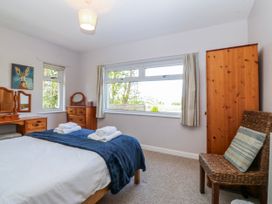A bedroom with a bed and dresser at Tirionfa in Talsarnau