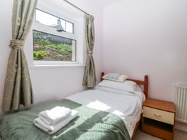 A bedroom with a bed and window at Tirionfa in Talsarnau
