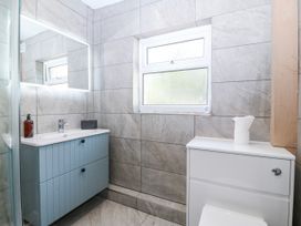 A bathroom with a sink, toilet, and mirror at Tirionfa in Talsarnau