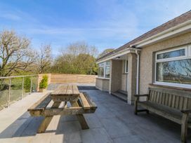 An outdoor space with a table and benches at Tirionfa in Talsarnau