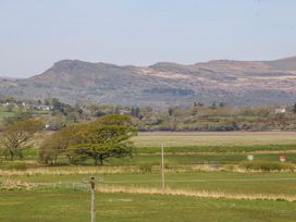 A view of a field with trees and a mountain at Tirionfa in Talsarnau