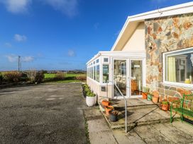 An exterior view of a house with a stone wall and planters at Tataramoa near Falmouth