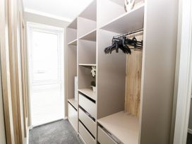 A walk-in closet with shelves drawers hangers and a window with blinds at Summerdown in Brean