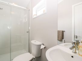 A bathroom with a shower enclosure a toilet a sink mirror and a window at Summerdown in Brean