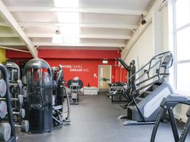 A gym room with various exercise machines and weights at Summerdown in Brean