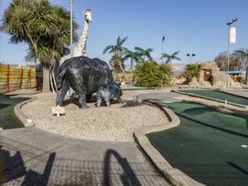 An outdoor mini golf course with artificial turf pathways and animal statues including a giraffe and elephants at Summerdown in Brean