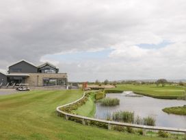 A building near a golf course with a pond and grassy landscape at Summerdown in Brean