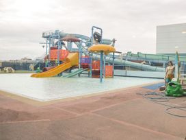 A water play area with slides and a shallow pool with statues at Summerdown in Brean