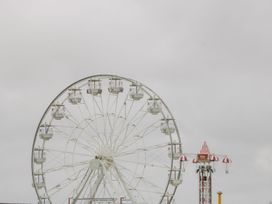 A ferris wheel and a parachute drop ride in an amusement park at Summerdown in Brean