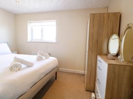 A bedroom with a bed with rolled towels a wooden wardrobe and a dresser with mirrors at Sweetacres in Hemsby