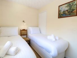 A bedroom with two single beds and rolled towels on each bed at Sweetacres in Hemsby