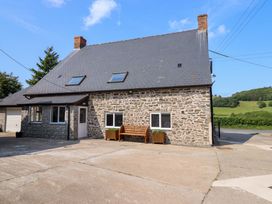 A house with stone exterior and a garden bench at Upper Dolarddyn Castle Caereinion