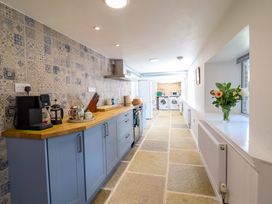 A kitchen with a refrigerator, oven, and washing machine at Upper Dolarddyn Castle Caereinion