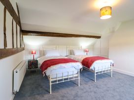 A bedroom with two beds and a bedside table at Upper Dolarddyn in Castle Caereinion