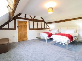 A bedroom with two beds and a wooden door at Upper Dolarddyn Castle Caereinion
