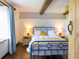 A bedroom with a blue bed frame and two bedside lamps at Upper Dolarddyn in Castle Caereinion