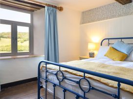 A bedroom with a bed and lamp at Upper Dolarddyn in Castle Caereinion