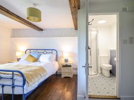 A bedroom with a bed and bathroom access at Upper Dolarddyn Castle Caereinion