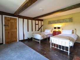 A bedroom with two beds and a chest of drawers at Upper Dolarddyn in Castle Caereinion