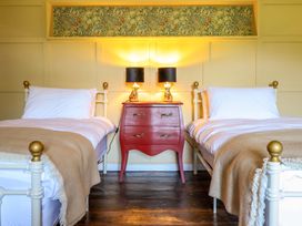 A bedroom with two beds and a nightstand at Upper Dolarddyn Castle Caereinion