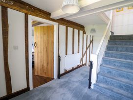 A hallway with a staircase and wooden door at Upper Dolarddyn in Castle Caereinion
