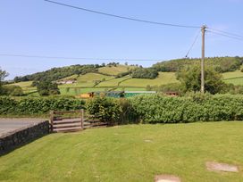 A train passing through a field with hills at Upper Dolarddyn in Castle Caereinion
