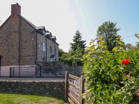 A house with a gate and flowers in the garden at Upper Dolarddyn in Castle Caereinion