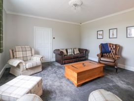 A living room with armchairs a sofa and a wooden coffee table at Bewholme in Skipsea