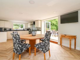 A kitchen and dining area with a round wooden table and four patterned chairs at Bewholme in Skipsea