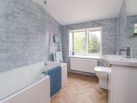 A bathroom with a bathtub a sink a toilet a ladder towel rack and a window at Bewholme in Skipsea
