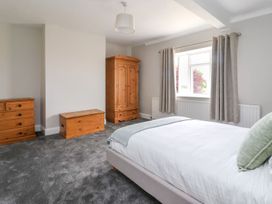 A bedroom with a bed a wooden wardrobe a wooden chest and a wooden dresser at Bewholme in Skipsea