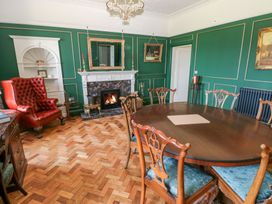 A dining room with a table and chairs at Coytrahen House in Coytrahen near Bettws