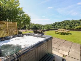 A hot tub with a picnic table in the garden at Coytrahen House near Bettws