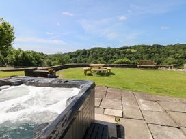 A garden with a hot tub and seating area at Coytrahen House near Bettws